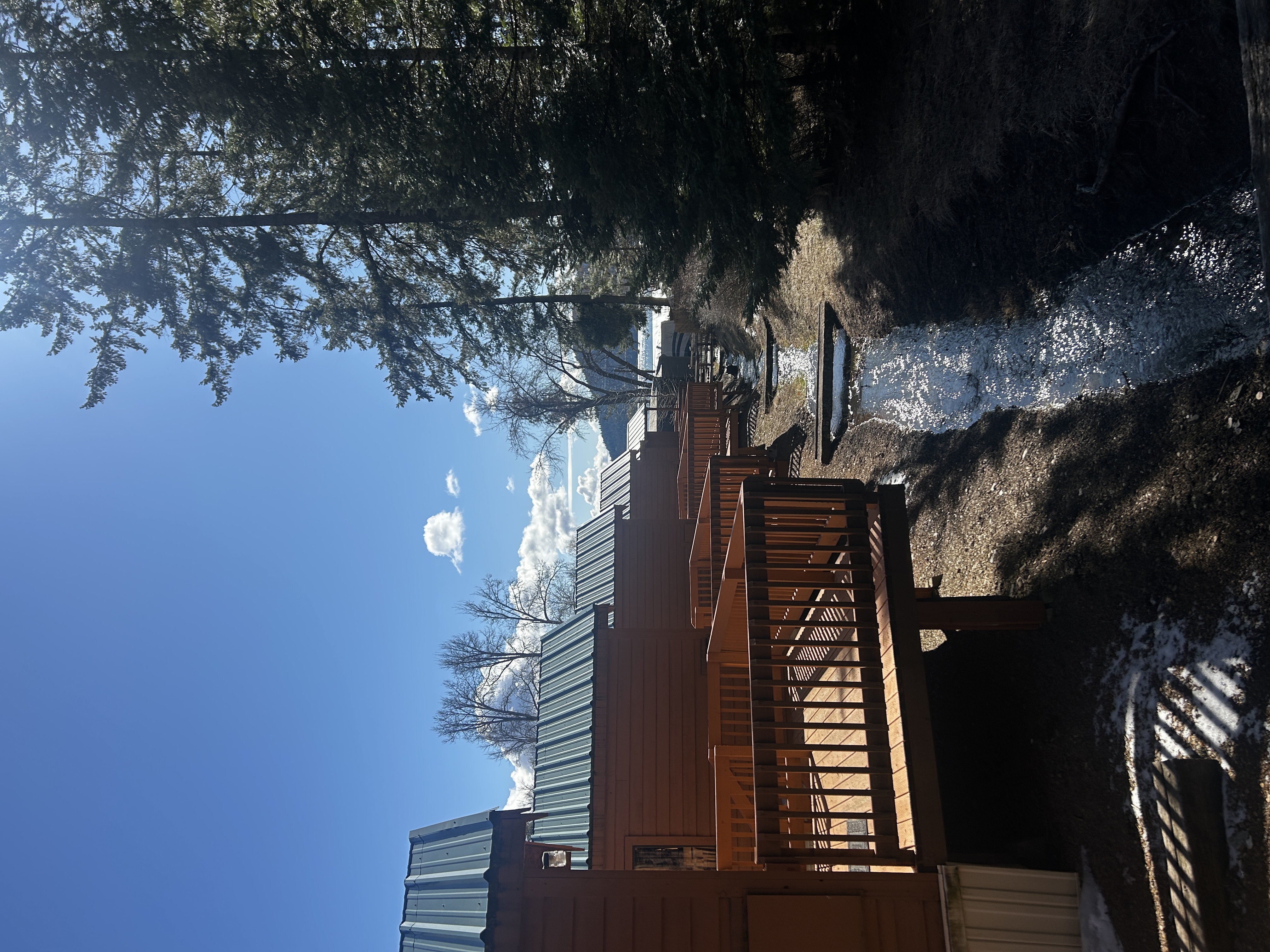 Wooden deck overlooking peaceful creek with mountain backdrop